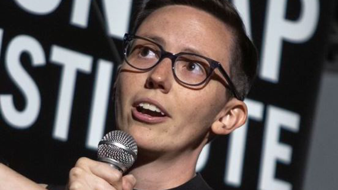 Katelyn Breivik speaks into a microphone at an event